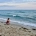 Imagen de una mujer de cuclillas frente al mar