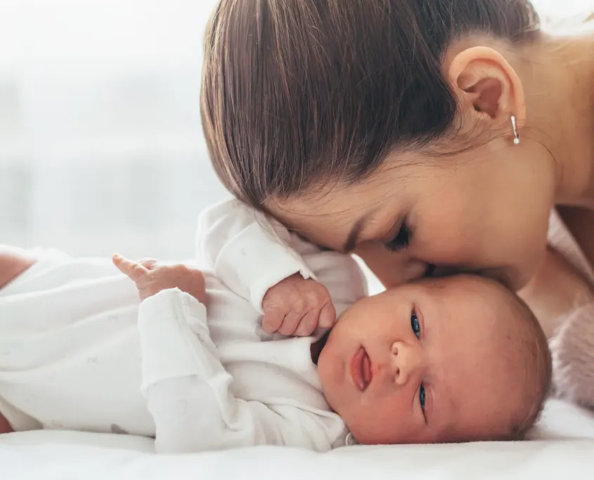 madre dado un beso a su bebé 