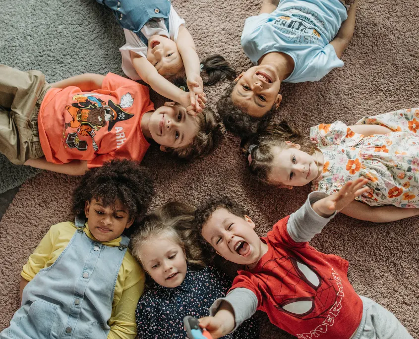 foto de niños tumbados en el suelo riendo