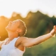 imagende mujer feliz en el campo con los brazos abiertos y con luz de atardecer